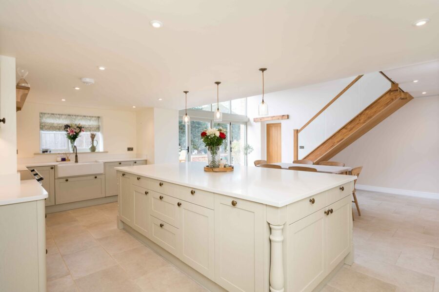 Old White Farmhouse kitchen with central island, traditional cabinetry and open-plan layout