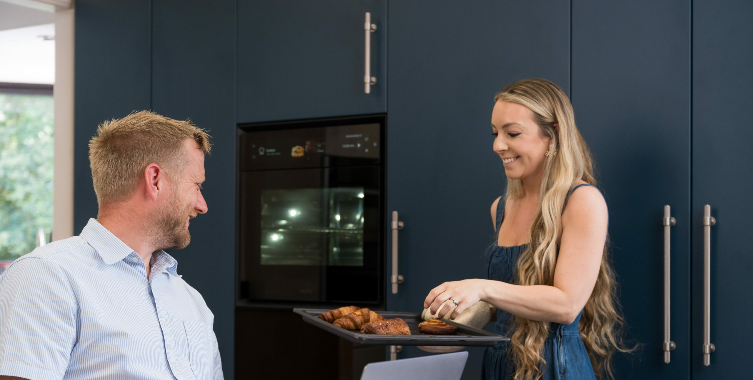 Young professional couple enjoying their new, bespoke Anglia Kitchens installation