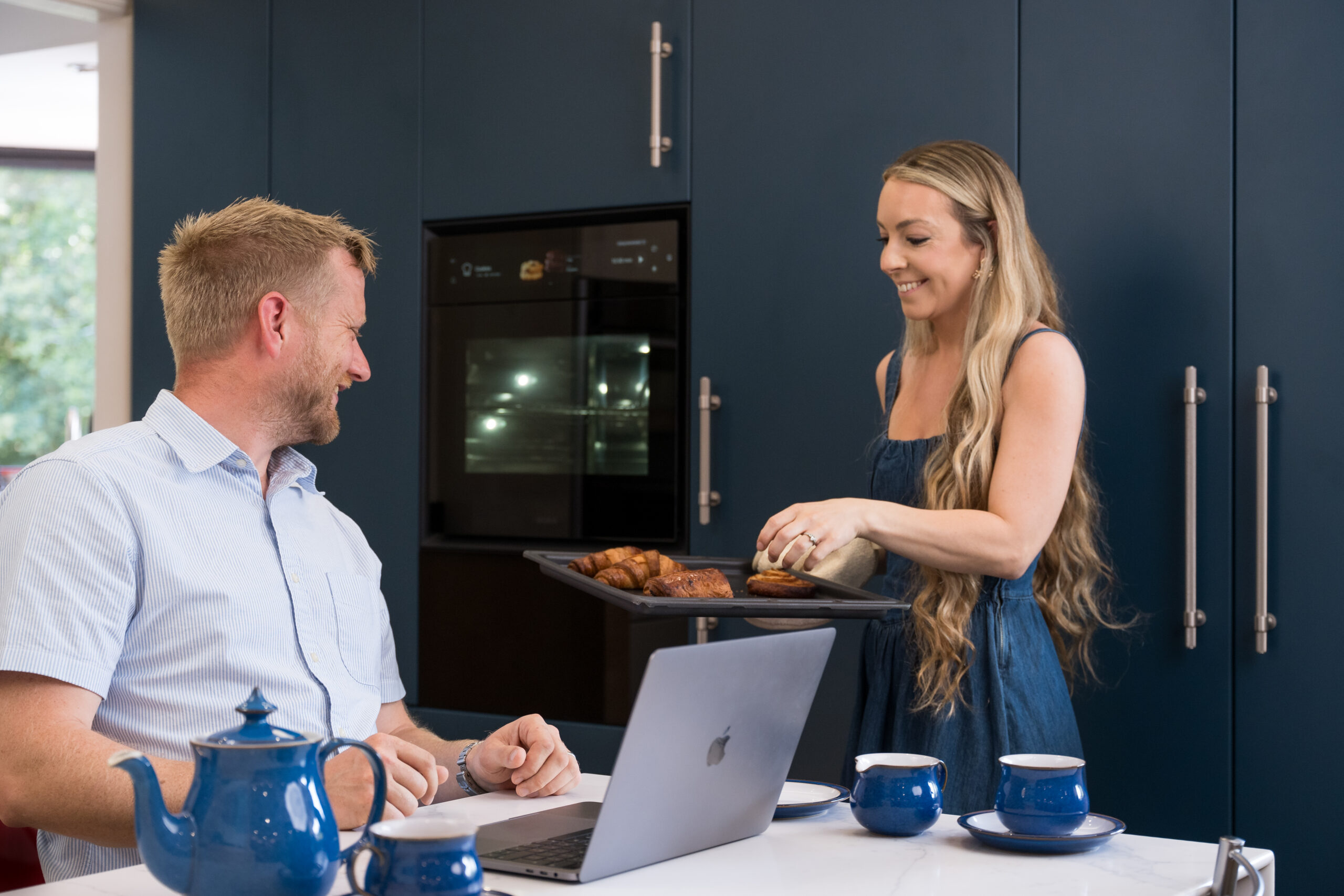 Young professional couple enjoying their new, bespoke Anglia Kitchens installation